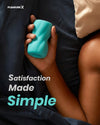 Person holding a teal toy with 'Pleasure X' branding and text 'Satisfaction Made Simple' of male mastrubation sex toy